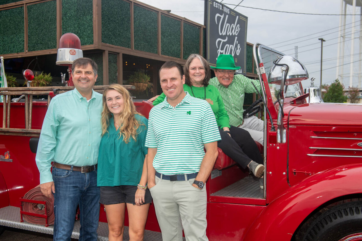 The Shingleton family and friends pose on a vintage firetruck in front of Uncle Earl's bar
