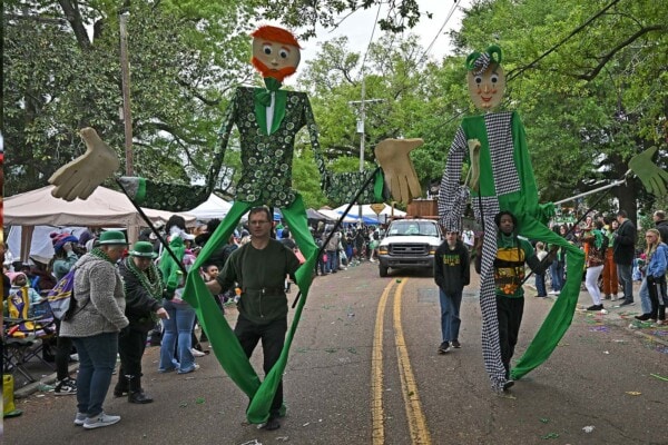 Walkers manipulate very tall puppets during the 2023 parade