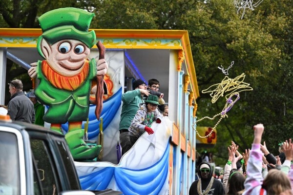 Riders throwing beads to the crowd from a float during the parade in 2023