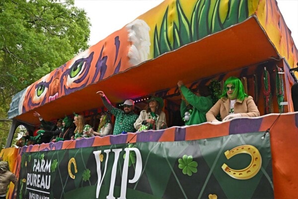 Riders throw beads to the crowd from a float during the 2023 parade