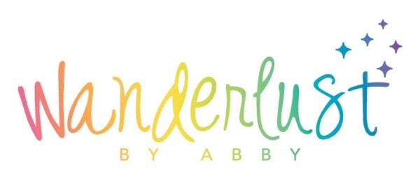 A colorful logo with the word "wanderlust" in a playful, cursive font, followed by "by Abby" in uppercase letters, and embellished with a sprinkle of stars to the right